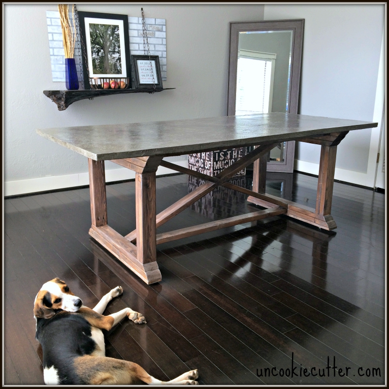 concrete table top with x supports, wood floor with dog